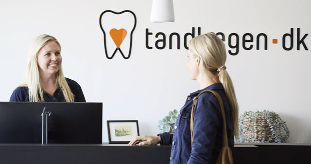 tandlæge nykøbing, receptionist smiler og byder velkommen